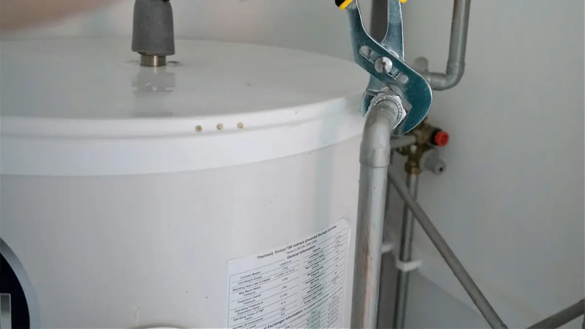 A white tank water heater with its supply valve and copper connector - Water Heater Repair in Tustin